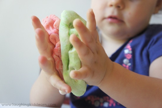 Squashing play dough together in an invitation to play