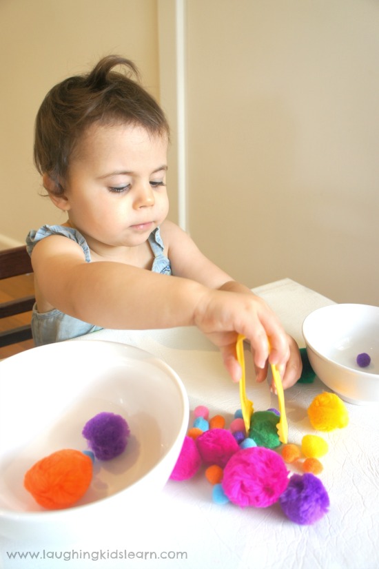 Toddler using tongs in fine motor activity