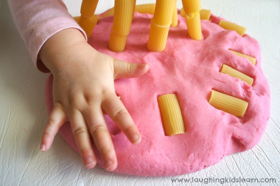 Pressing Pasta into Play Dough