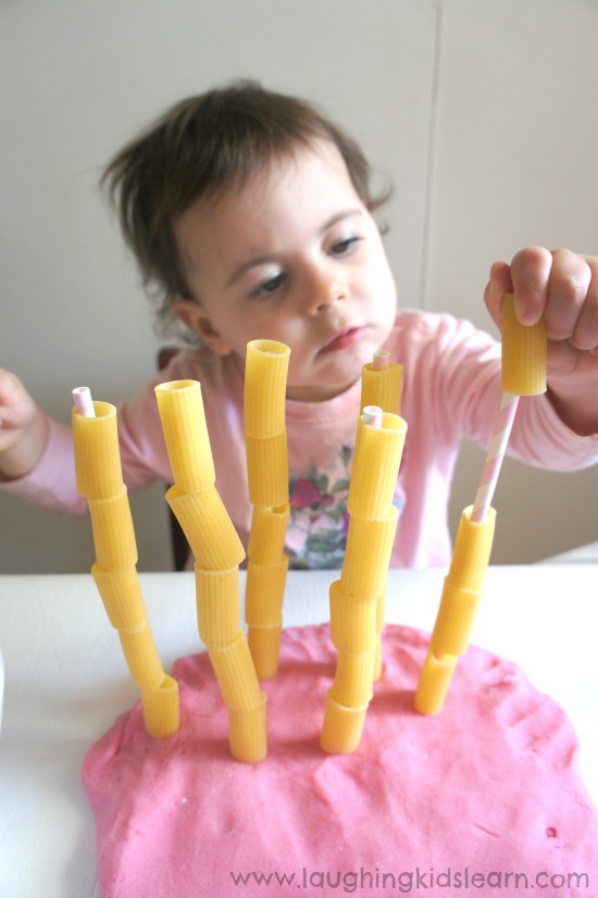 Threading pasta onto straws for fine motor skill development