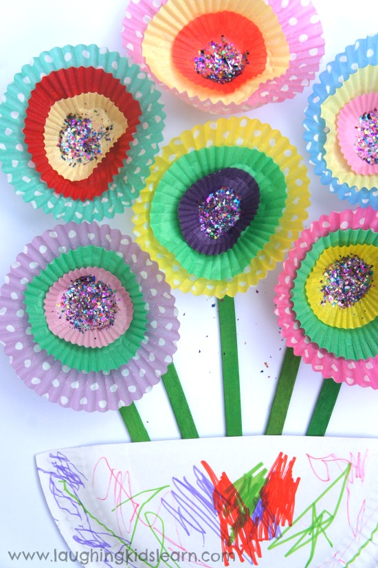Flower crafts for toddlers using glitter, glue, paper plates, popsicle sticks, and cupcake liners.