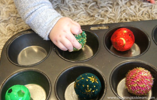 Baby playing with sensory balls on tray