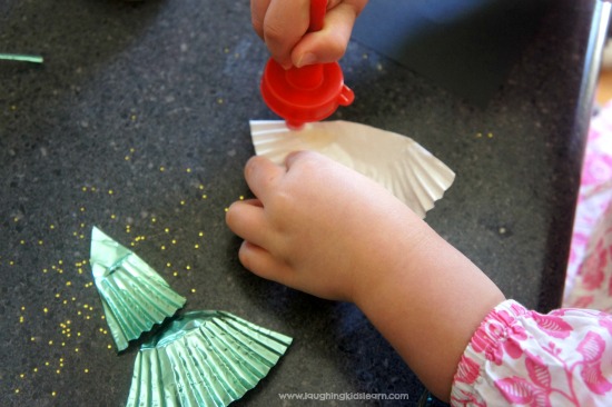Pasting Christmas Tree with cupcake liner. Simple craft for kids.