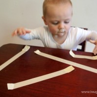 baby play game with sticky tape and pulling it off a table. Great for fine motor development.