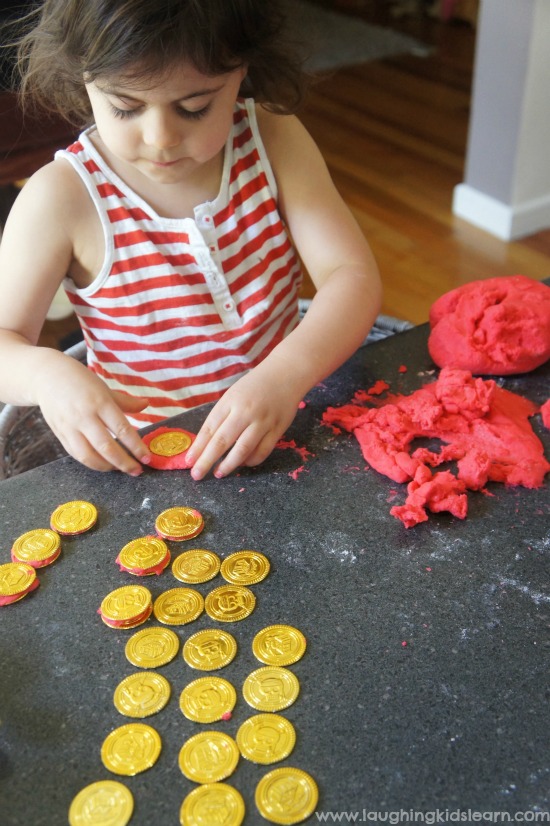 playing with gold coins and red playdough