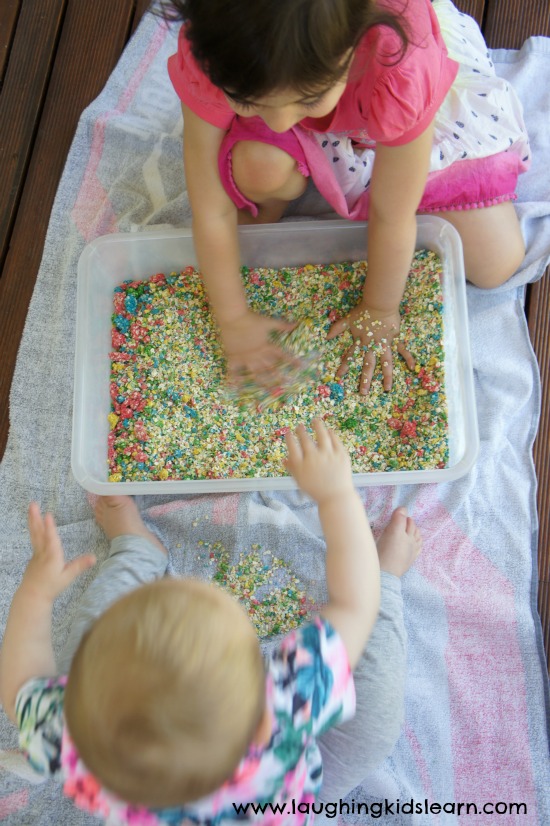 preschooler and toddler playing with sensory oats