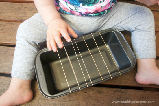 baby musical guitar instrument that is homemade and kids can enjoy playing. Just use a baking tin and rubber bands.
