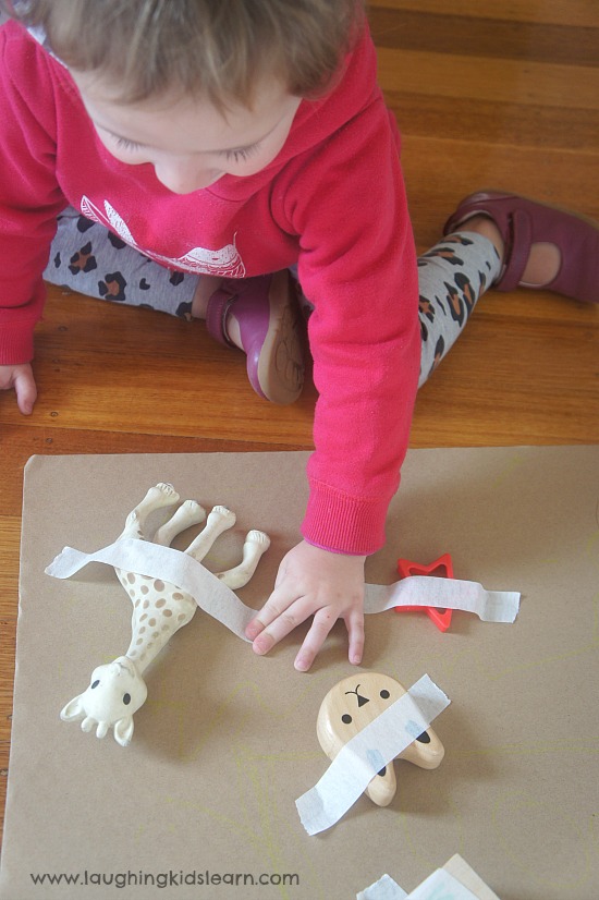 pulling off sticky tape from toys for fine motor skill development