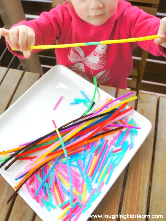 threading straw pieces on to long pipe cleaners for fine motor