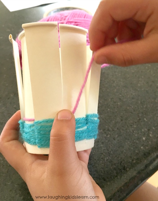 weaving yarn on a paper cup