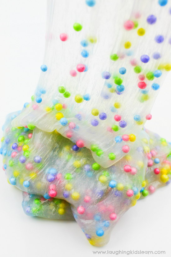 kneading slime with hands that has liquid starch and glue. Fun sensory play slime that's easy to make. #slime #sensoryslime #foamslime #slimerecipe #kidsscience #simpleslime #glueslime #elmerglue #makingslime #makeslime #recipeforslime #funslime #texturedslime #sensoryplay #sensoryprocessing #rainbowcolors #rainbowslime colorfulslime #easyslimerecipe #funslime #makeslime #styrofoamballs #stretchyslime #kbn #floam #funtomakeslime #threeingredients #messfree #simplerecipeforkids #kidsplay #messyplay #pastelcolors mixing slime with styrofoam balls.