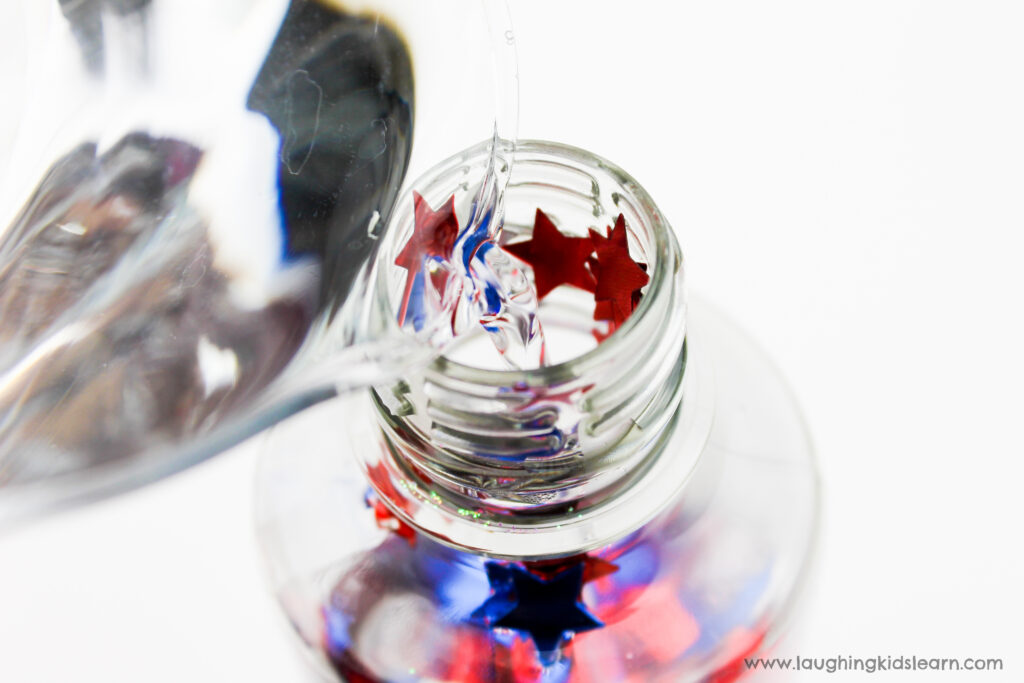 Adding water to a patriotic sensory bottle. 