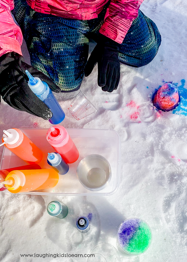 Kids playing in snow and using bottles of colored water to decorate snow and make art.