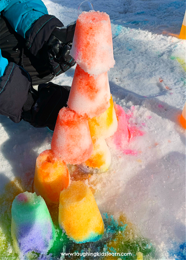 Tower of snow that kids have decorated with paints.