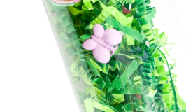 Easter-themed sensory bottle with green paper and charms