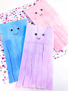 Adorable paper bag jellyfish with rainbow-colored tentacles, a hit for kids' crafting on Pinterest.